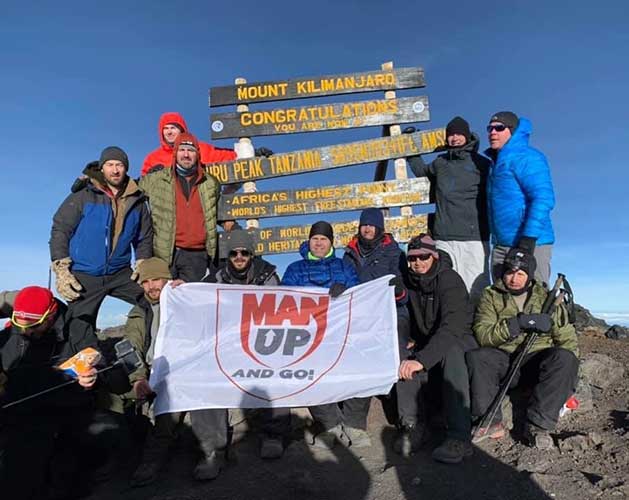 Mark Acre in front of the sign on top of Mount Kilimanjaro