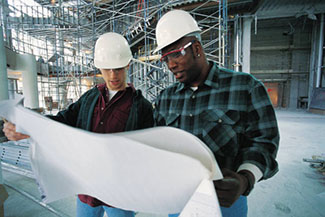 Two constructions workers looking at blueprints.