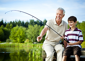 Grandfather and grandson fishing together.