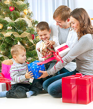 Family of 4 opening Christmas presents.