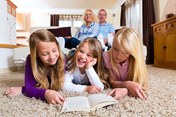 Happy couple with three kids in their living room.