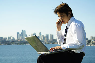 A businessman working outdoors at a park.