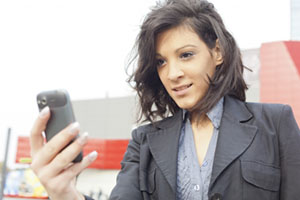 A woman looks at her cell phone on the go.