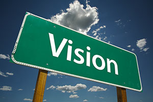 A green road sign that says, "Vision."